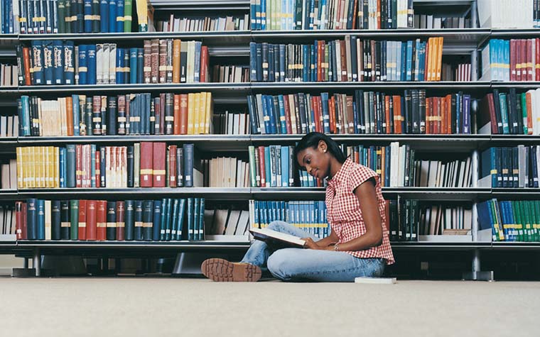 etudiante en train de lire à la bibliothèque isfin