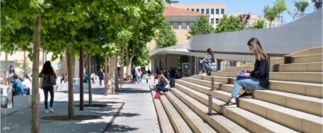 Photo montrant une étudiante entrain de lire un livre sur les escaliers du campus Schuman