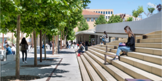 Photo montrant une étudiante entrain de lire un livre sur les escaliers du campus Schuman